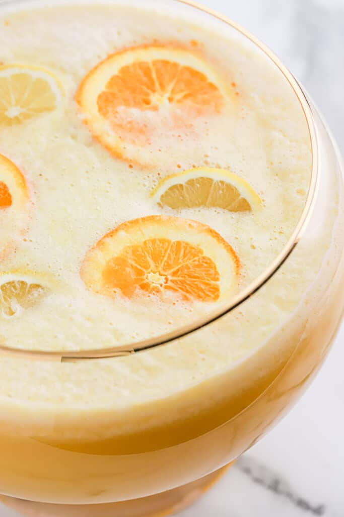 Overhead of fully made punch bowl filled with sliced oranges.