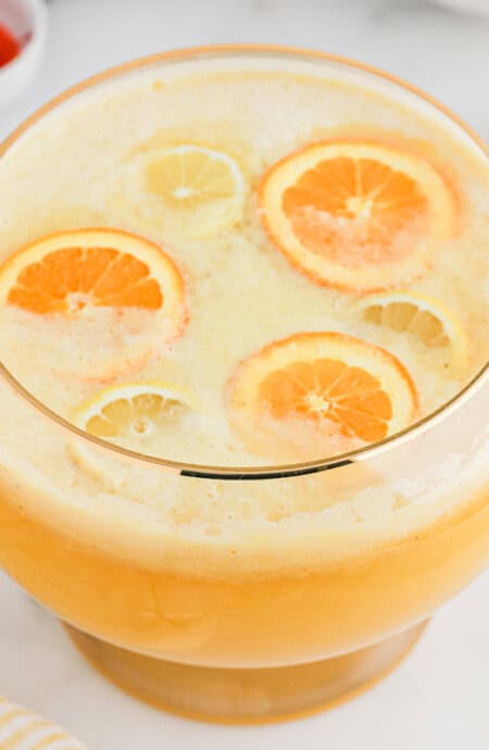Overhead of fully made fruit punch bowl filled with sliced oranges.