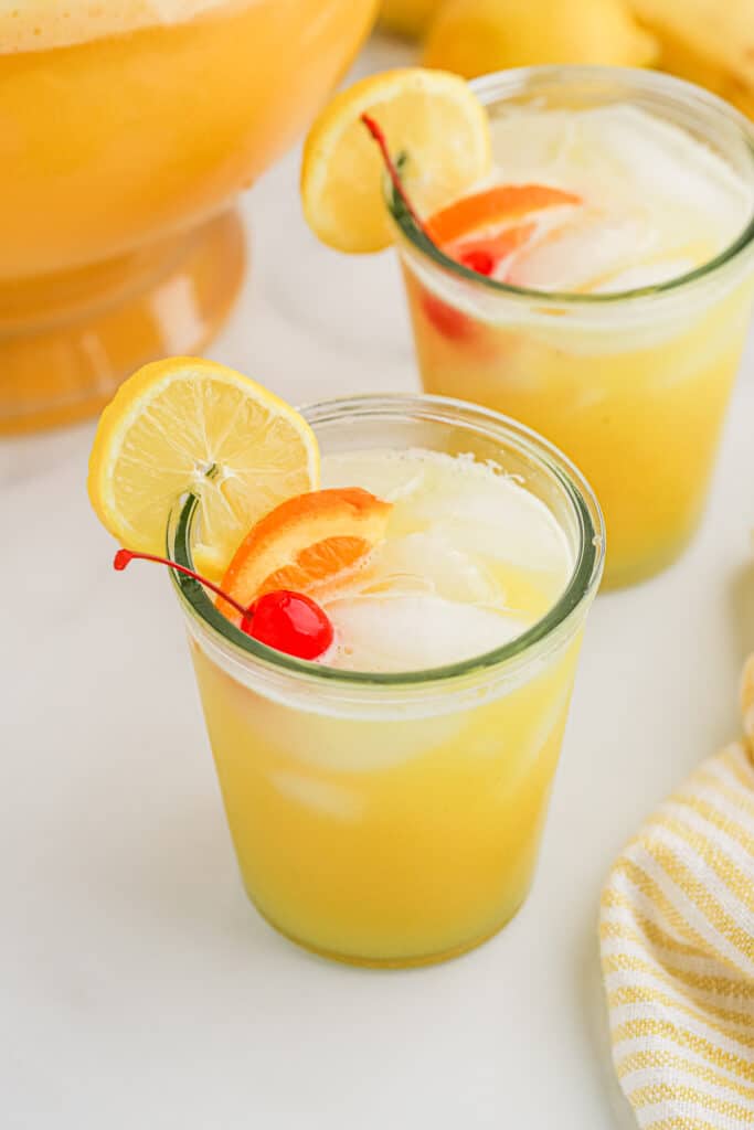 Two glasses filled with punch and fresh fruit.
