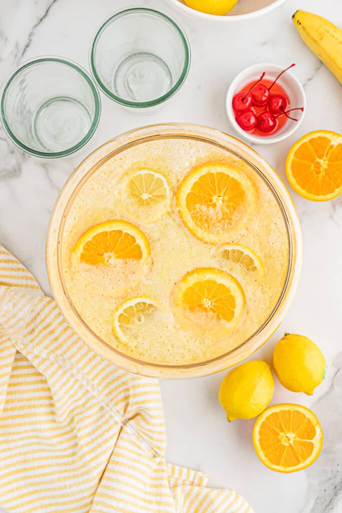 Overhead of fully made punch bowl filled with sliced oranges.