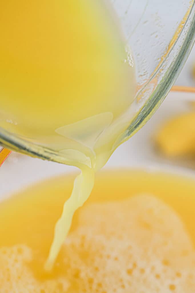 Orange juice being added to the punch bowl.