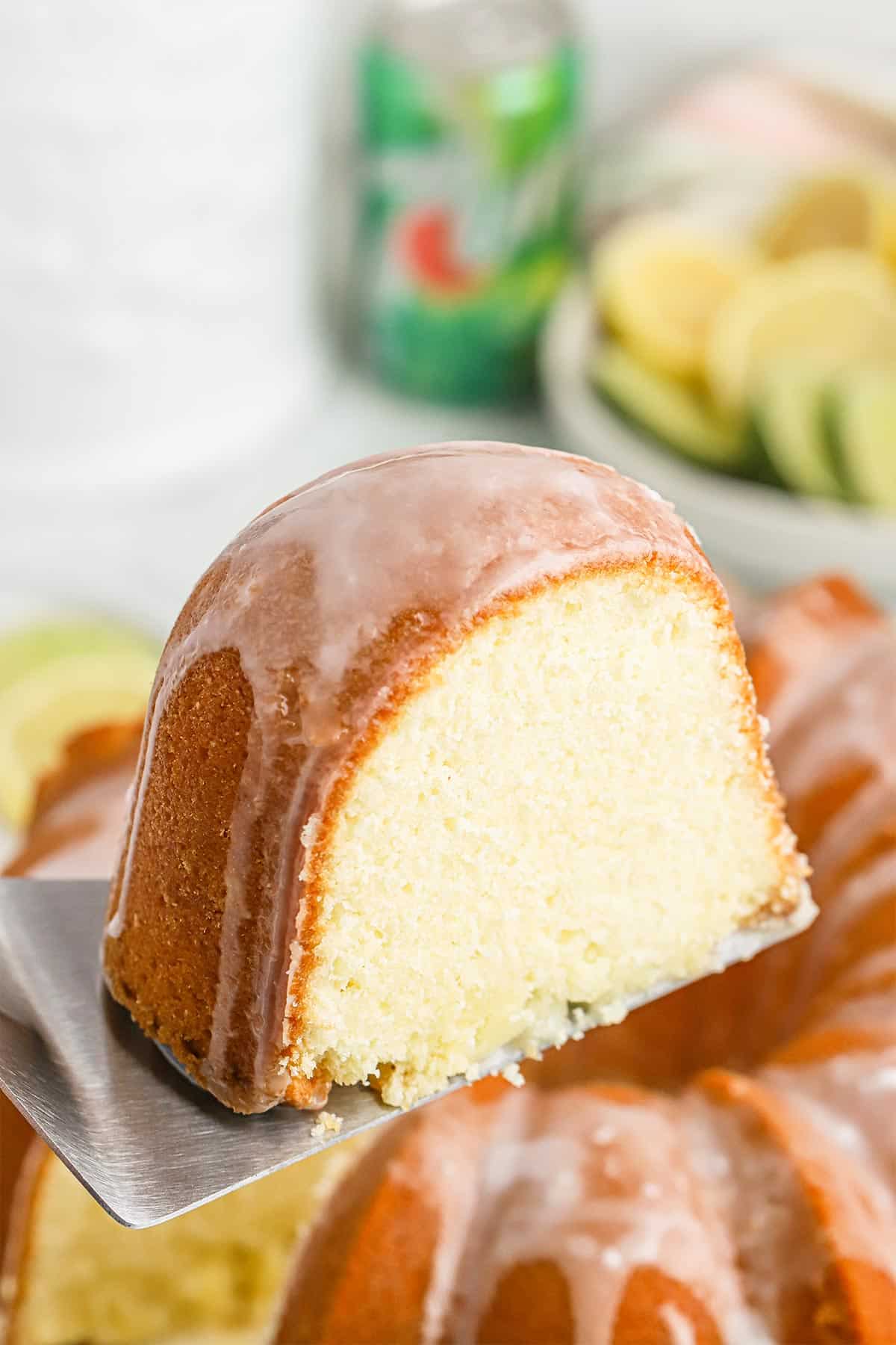 Slice of 7 up cake recipe on a spatula up over the full cake.