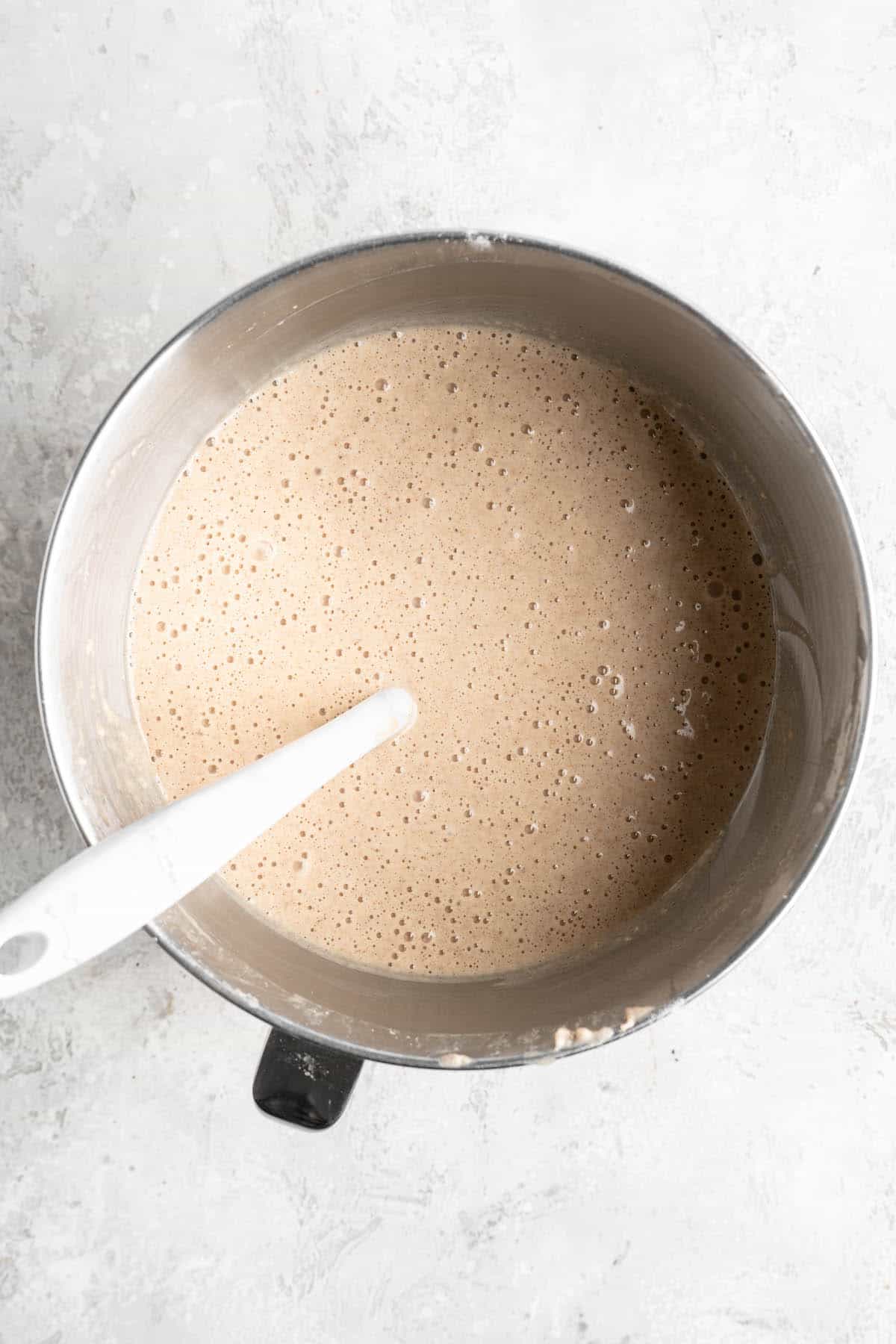 Cake batter in a mixing bowl after being mixed together on a white countertop