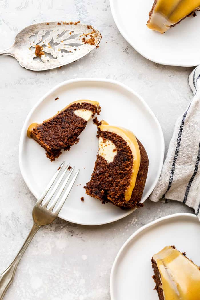 A slice of chocolate cake with cream cheese filling on white plate with fork