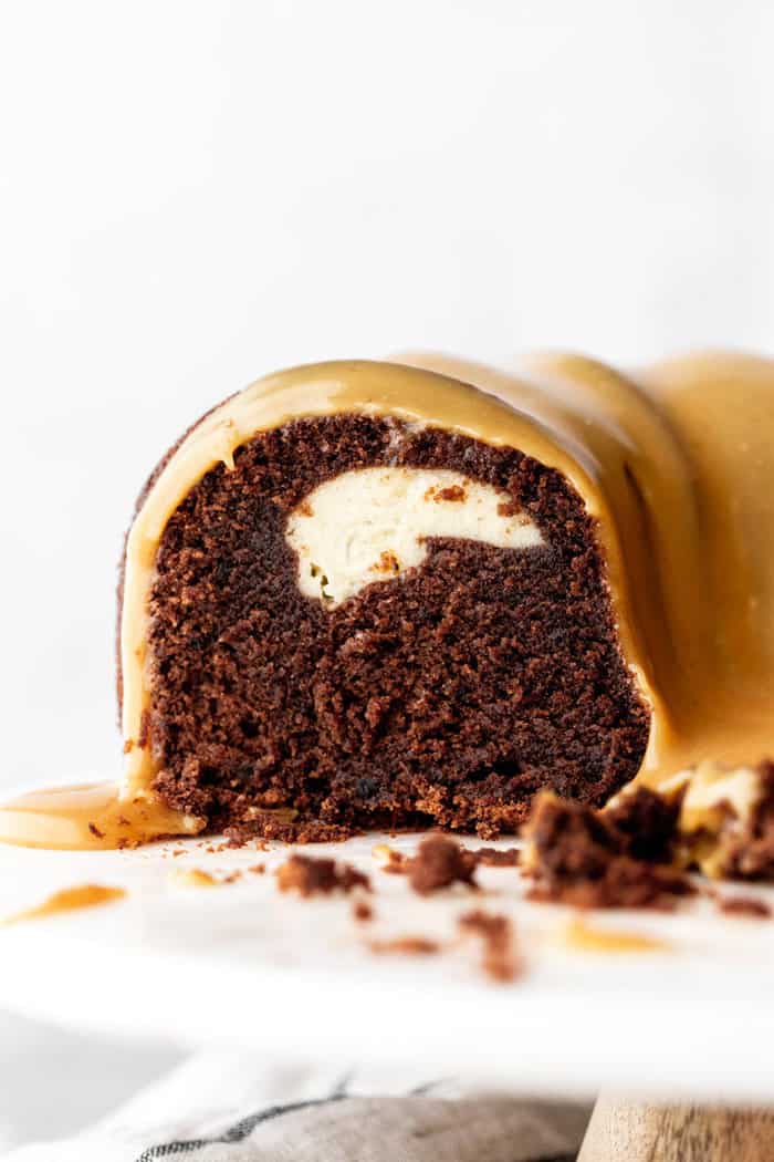 Close up of Baileys Chocolate Bundt Cake recipe with cream cheese filling and white chocolate ganache