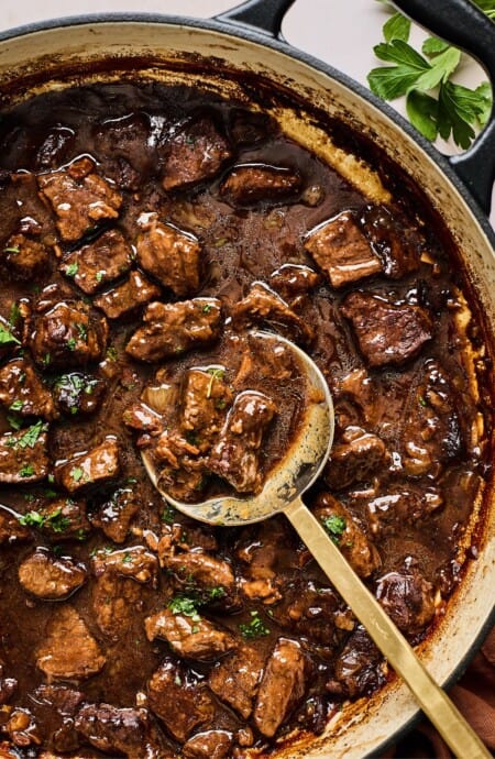 A spoon digging into the best beef tips and gravy ready to serve