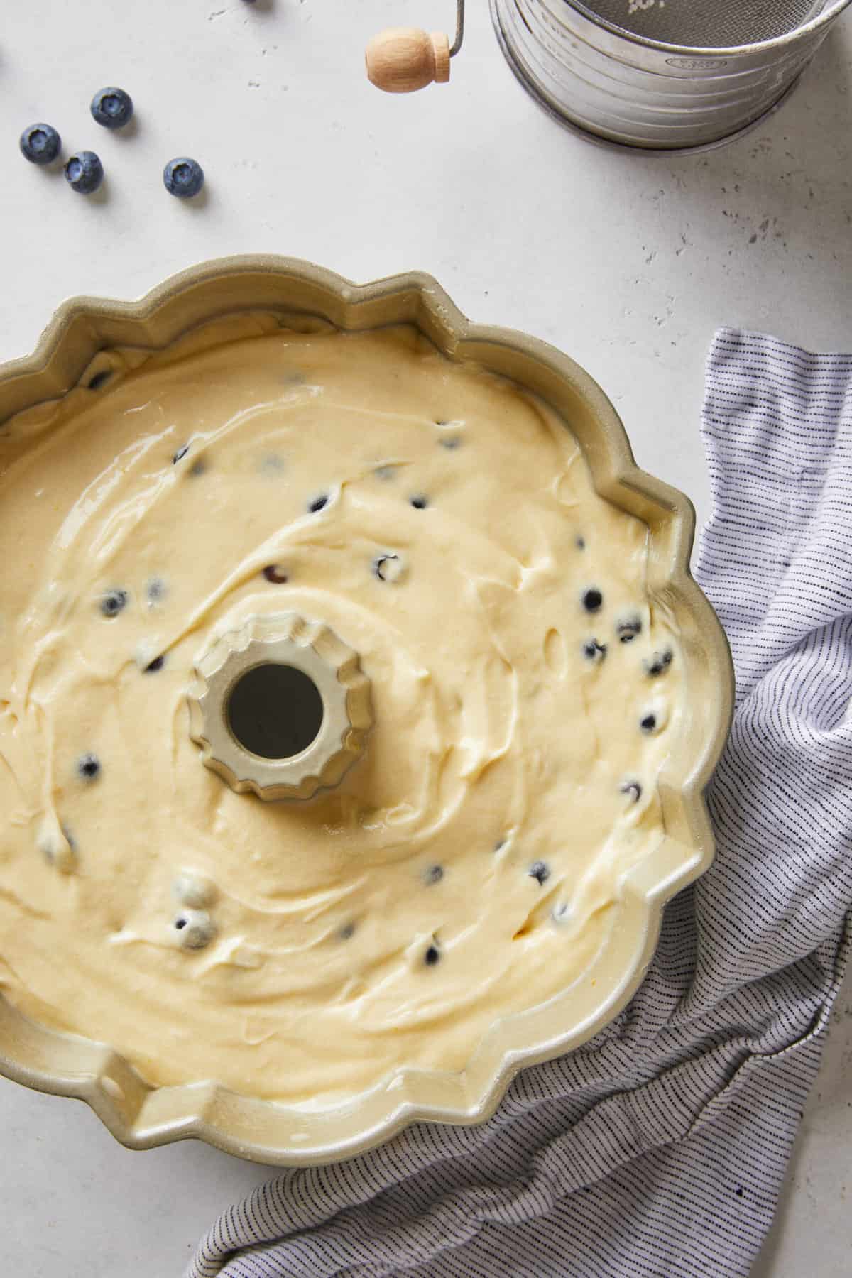 Orange batter with blueberries in a bundt pan