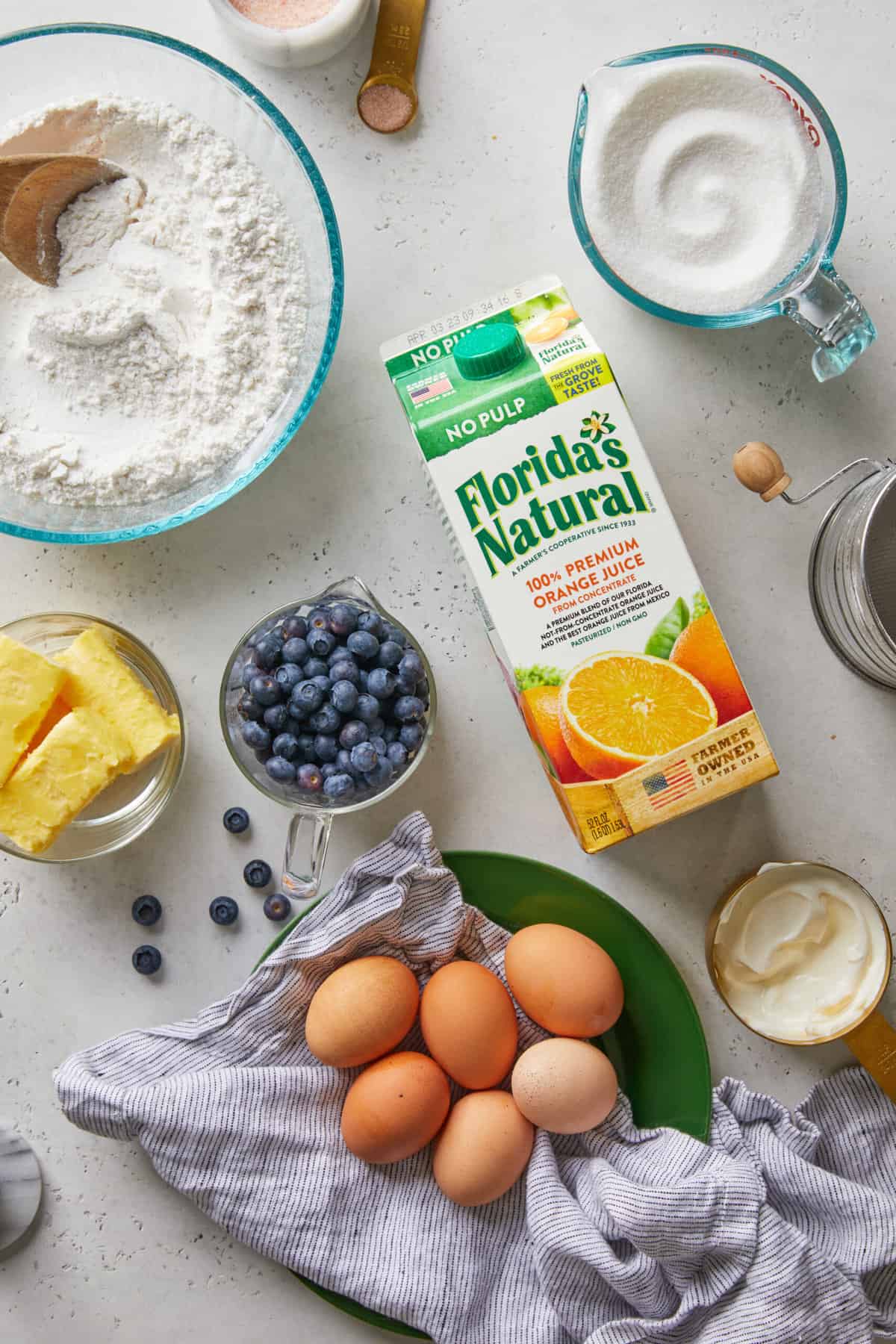Ingredients in different bowls to make an orange cake with blueberries