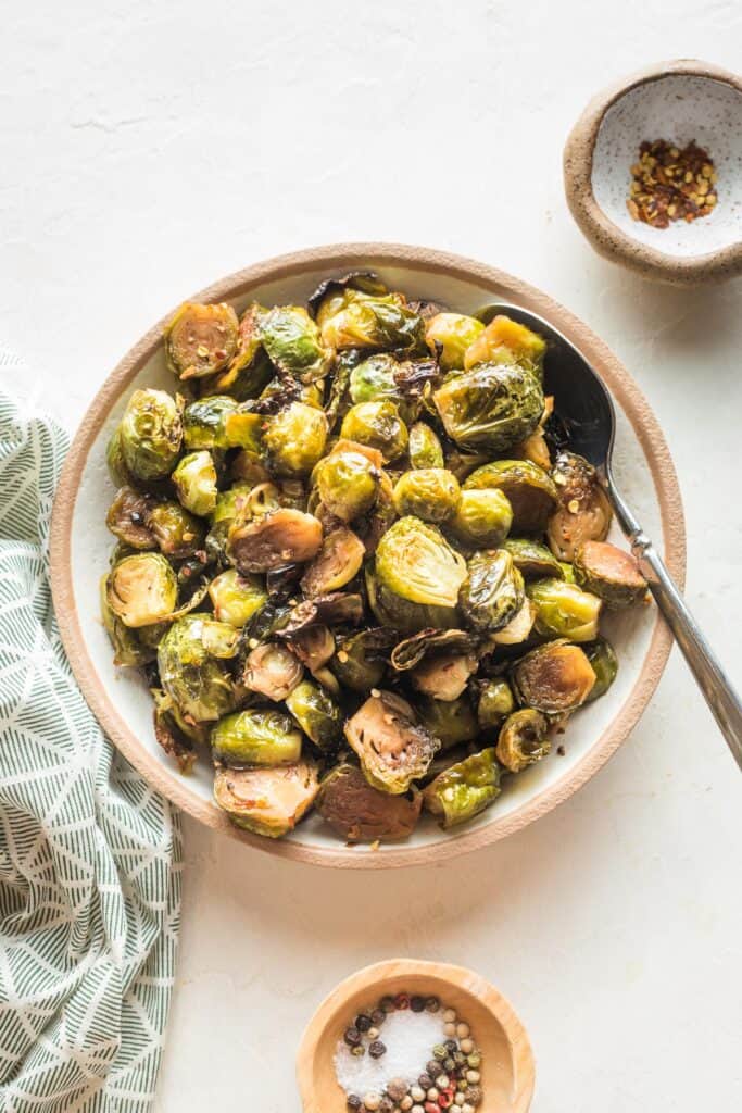 overhead of a bowl full of roasted brussels sprouts and a spoon