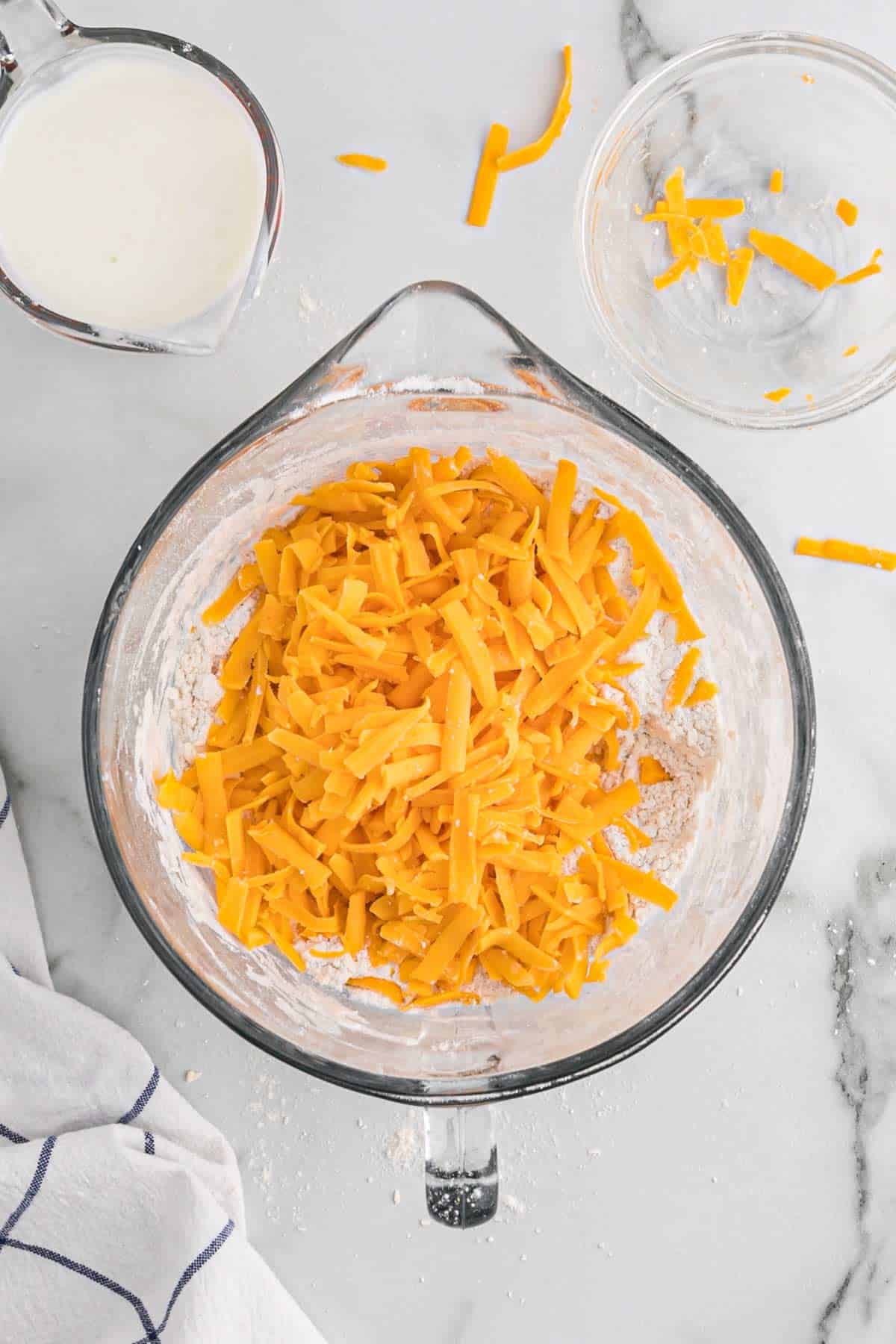 Cheddar cheese added to the bowl of butter and flour.