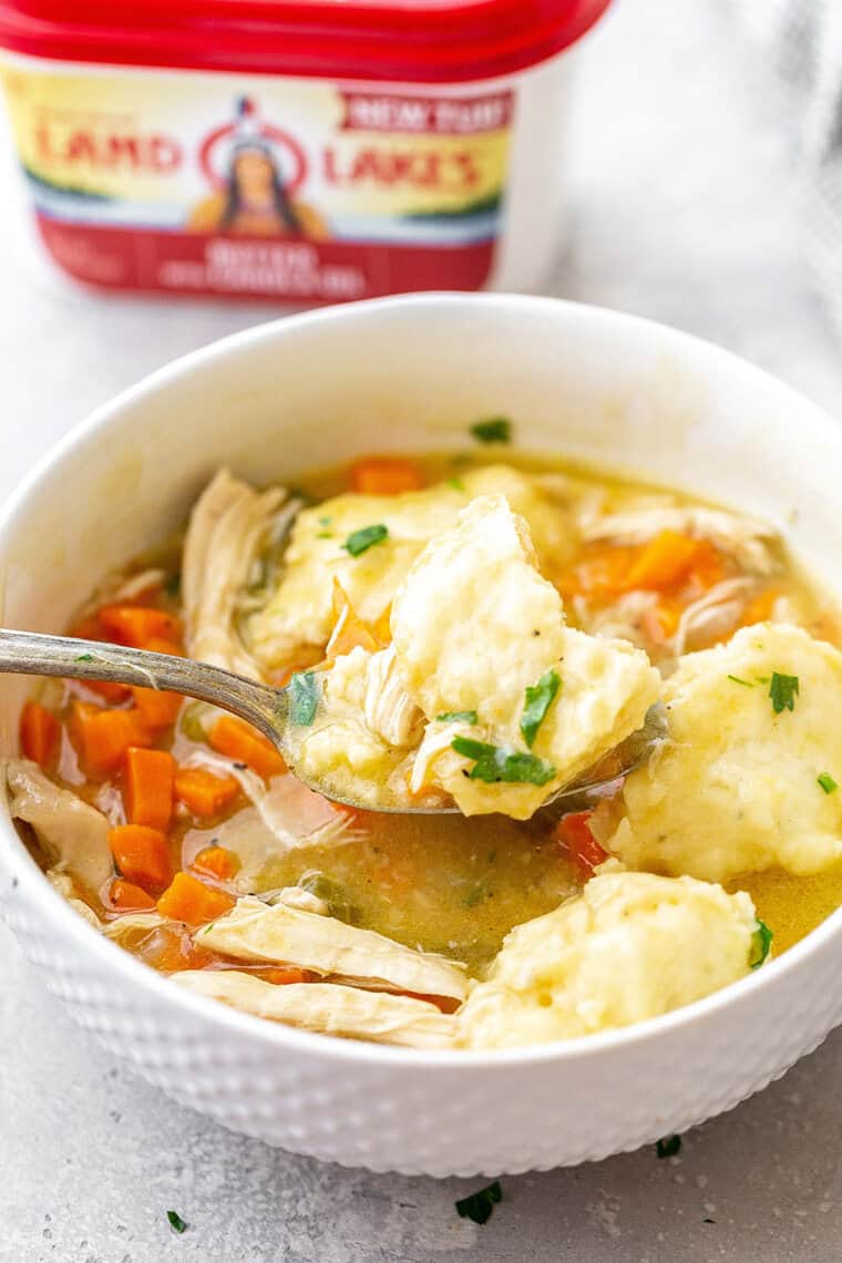 Spoon digging into homemade chicken and dumplings