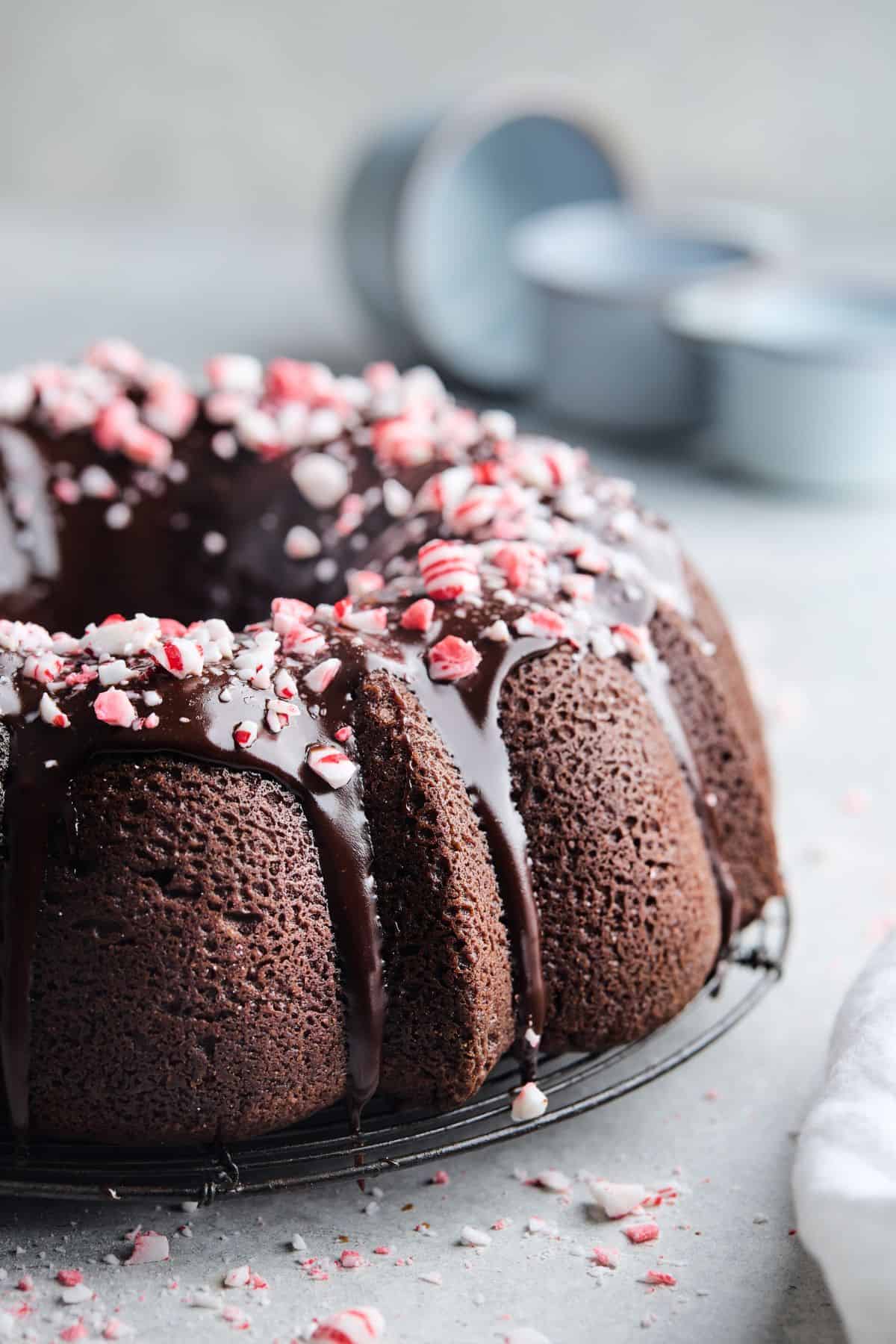 A chocolate peppermint pound cake close up with a chocolate ganache glaze and crushed peppermint on top