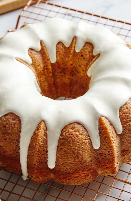 A delicious cinnamon roll pound cake with a piece served on a blue swirled plate