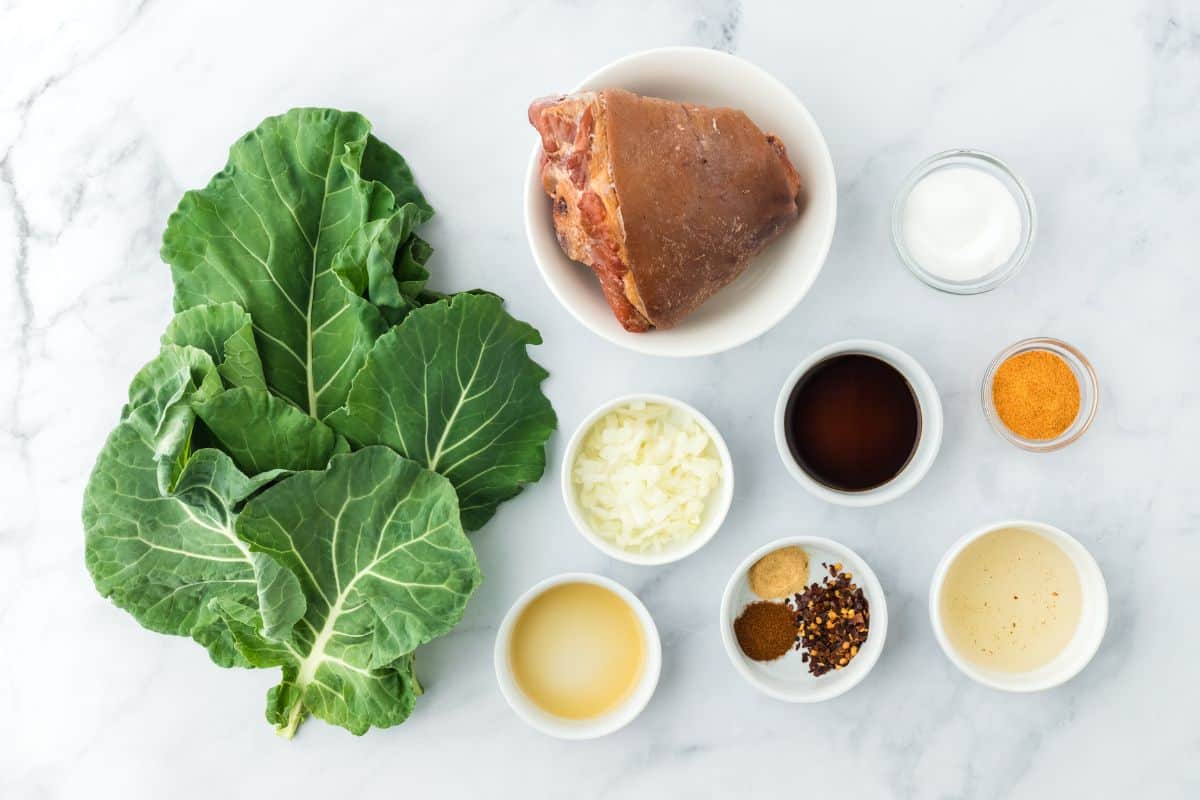 Overhead shot of ingredients to make this collard greens recipe on the table before cooking