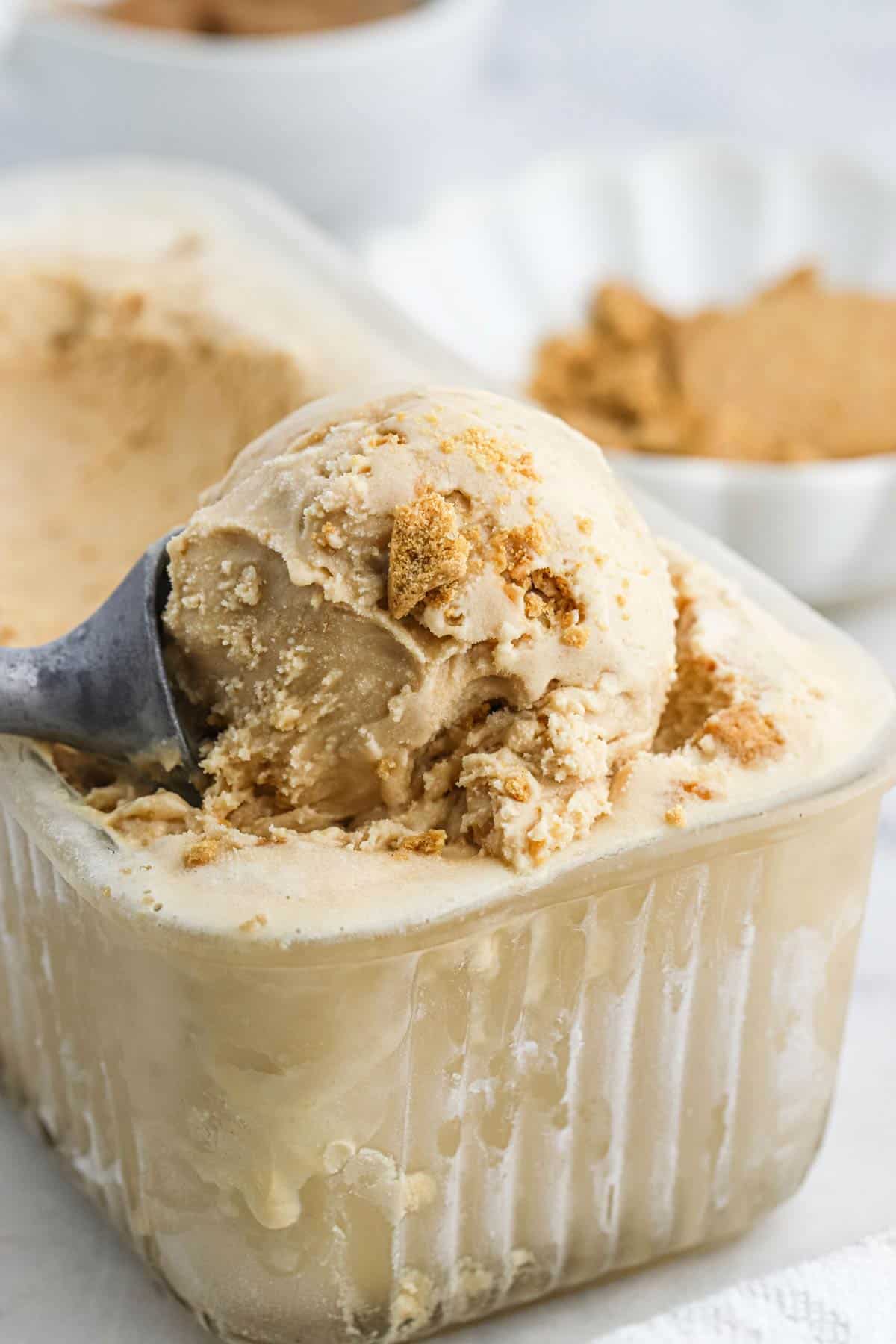 cookie butter ice cream Cookie butter ice cream in a container with a utensil scooping up some to serve.