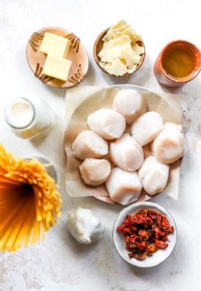 Ingredients for pasta including fresh scallops, butter, sun dried tomatoes and pasta