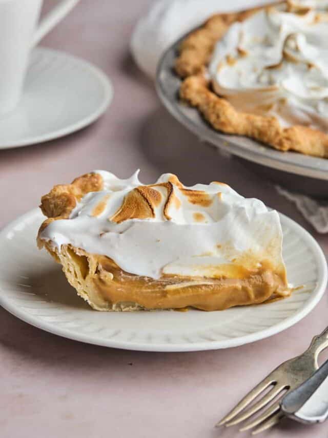 slice of butterscotch pie on a white plate with toasted meringue.