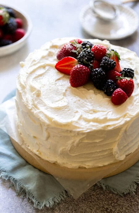 a devil's food cake frosted with swiss meringue buttercream and topped with fresh berries
