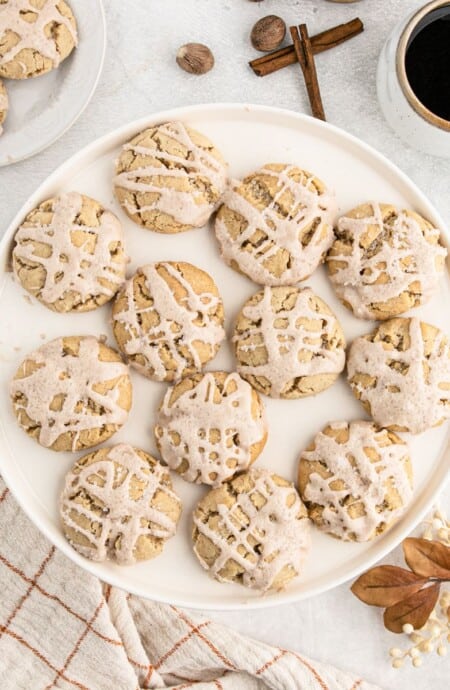 A plate of iced butter cookies with eggnog on the table.