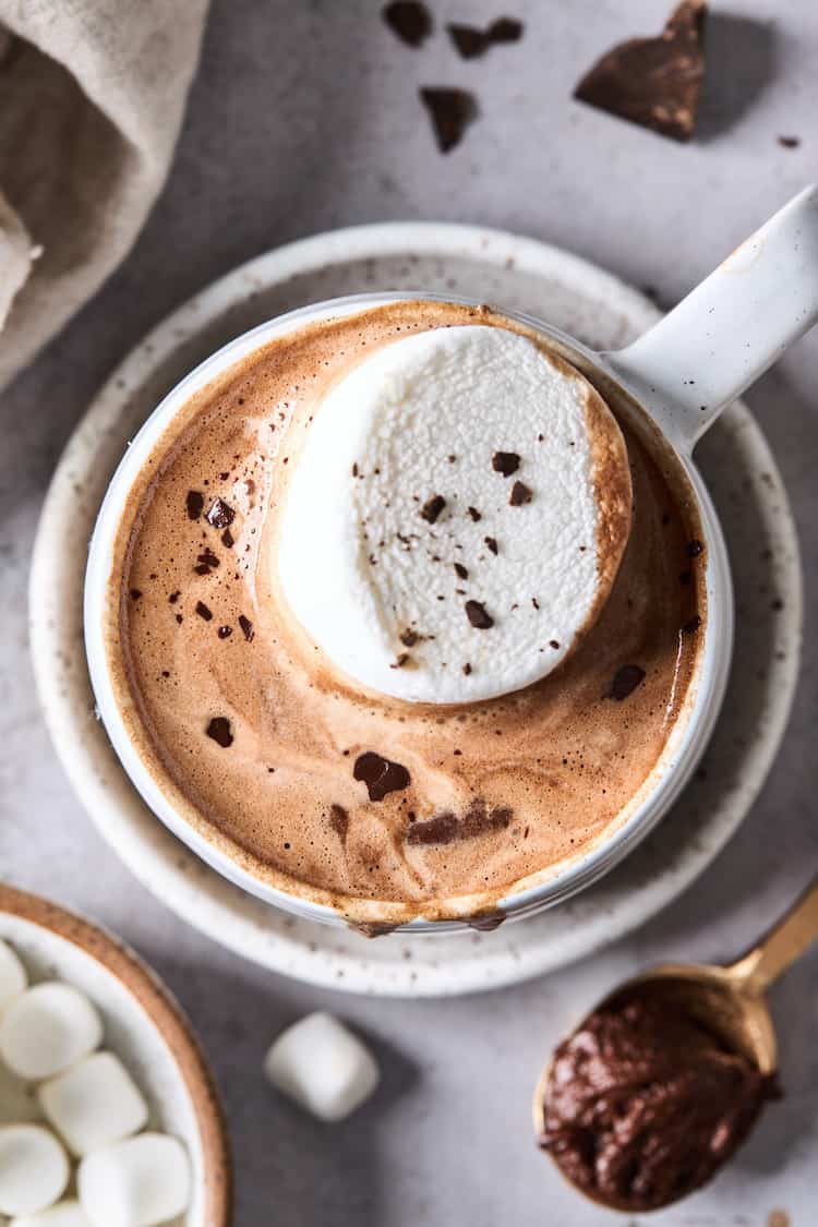 A close up of a mug of Parisian hot chocolate with a vanilla marshmallow on top and chocolate shavings