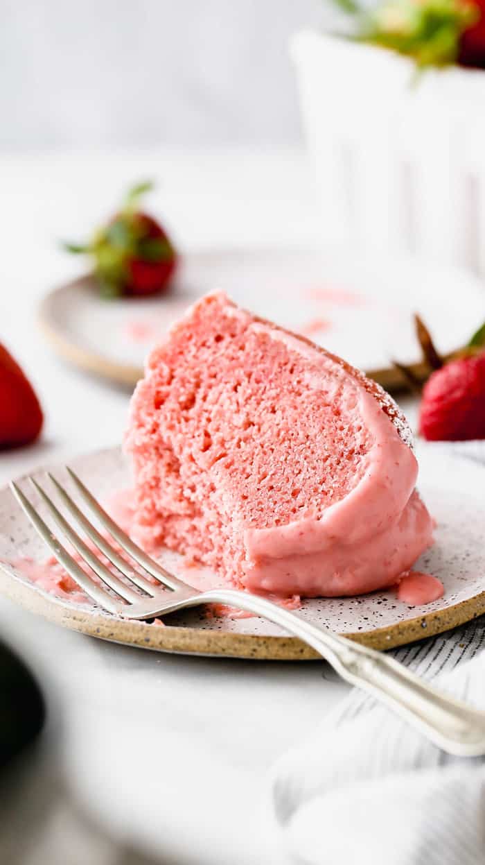 A slice of strawberry pound cake recipe on a white plate with a silver fork