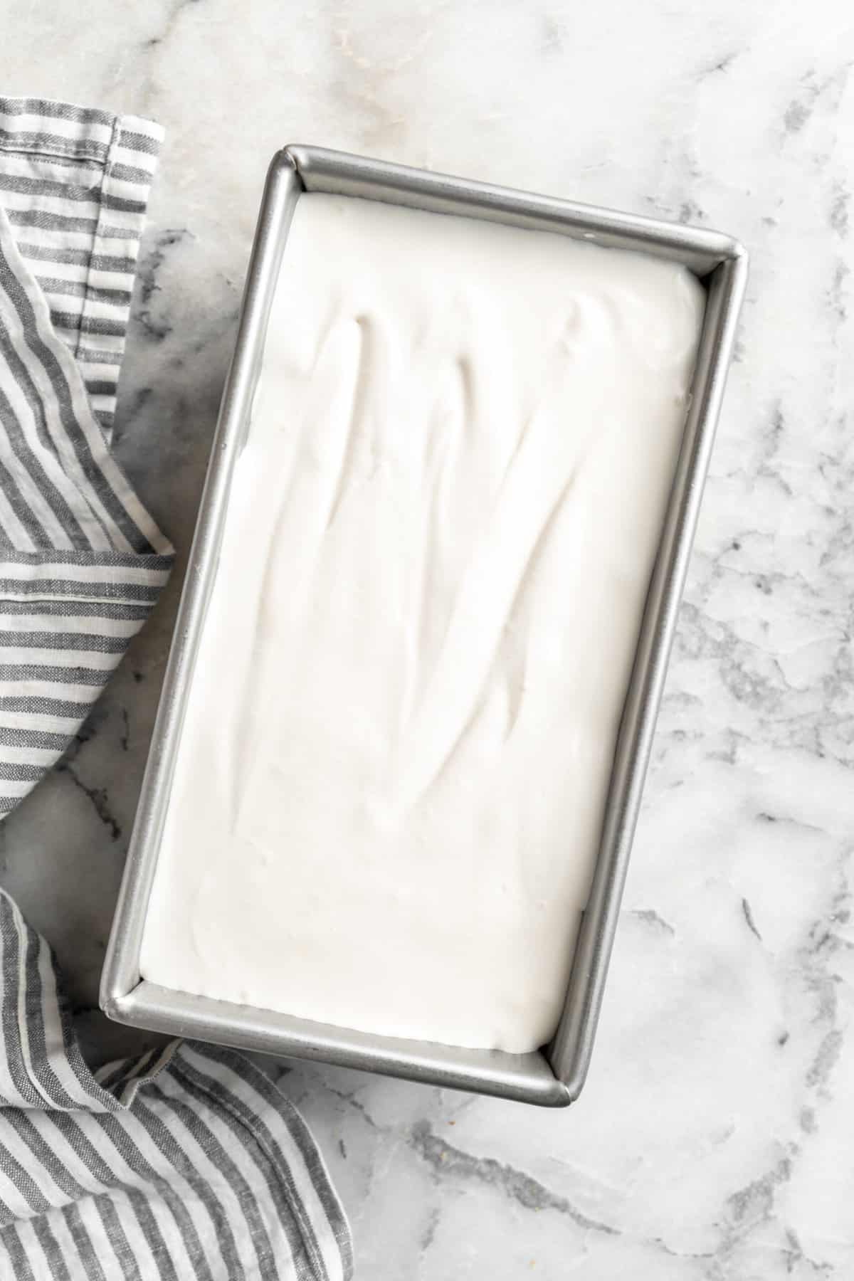 Homemade ice cream frozen in a metal loaf pan.