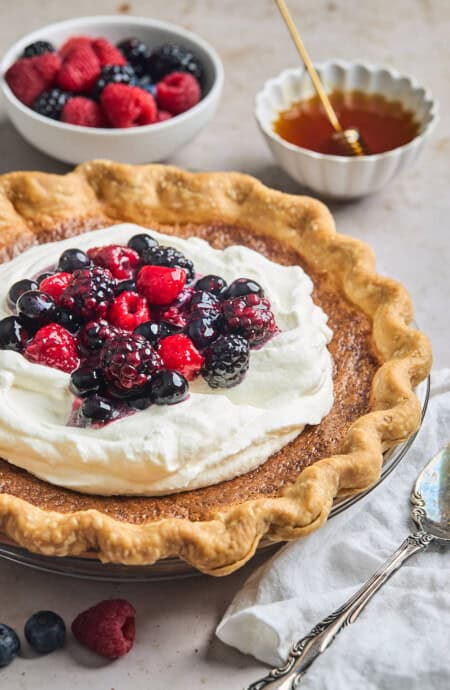 Huckleberry cream pie topped with fresh whipped cream and berries.