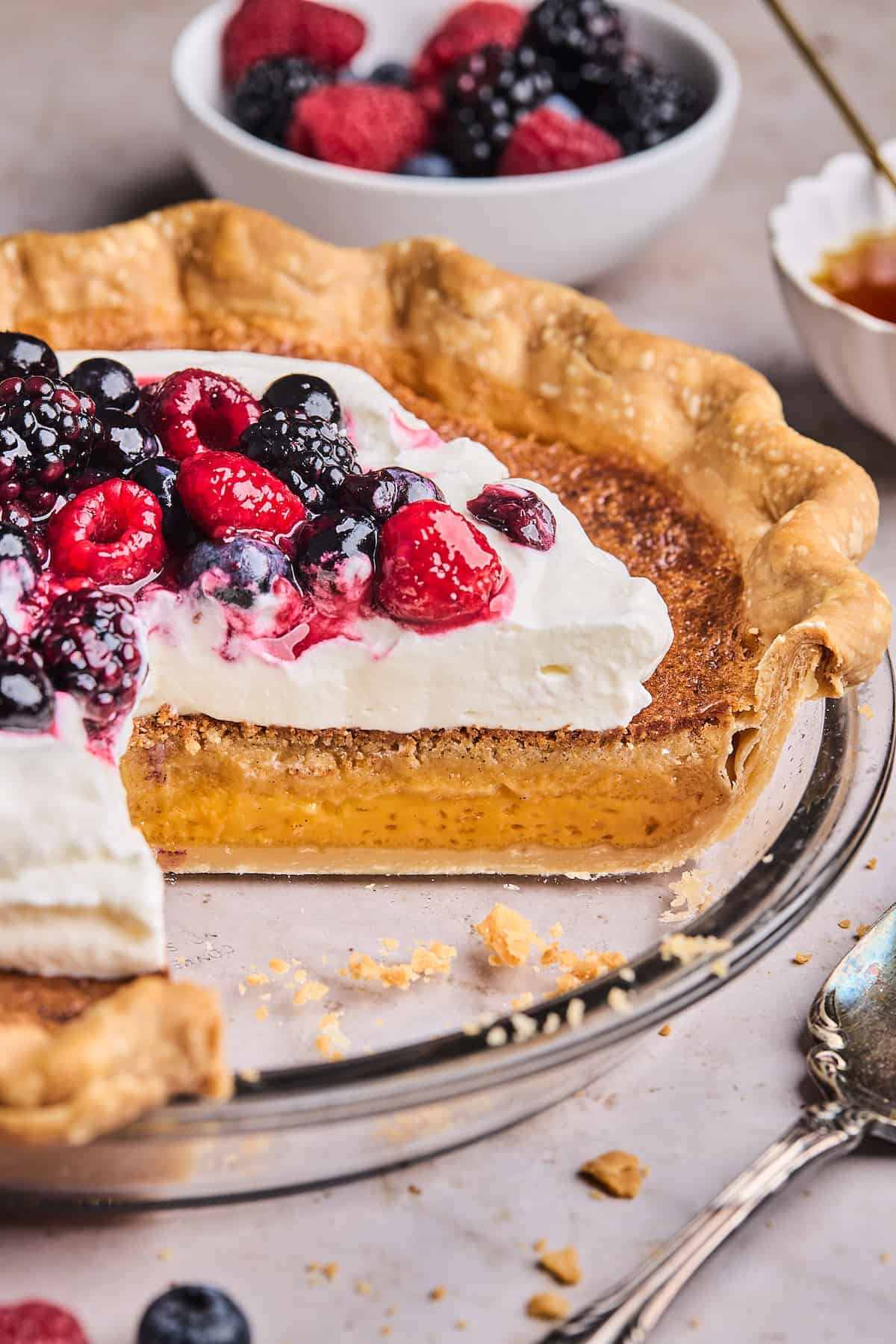 Salted Huckleberry Honey Pie with a Berry sauce and a slice missing