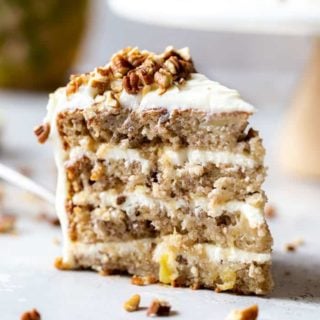 A lovely slice of a hummingbird cake recipe with pineapple cream cheese frosting and nuts ready to eat