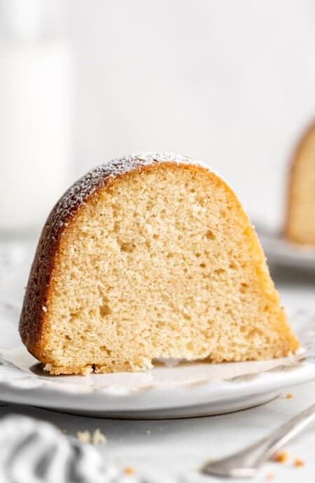 Close up of two slices of Kentucky Butter Cake on white plates.