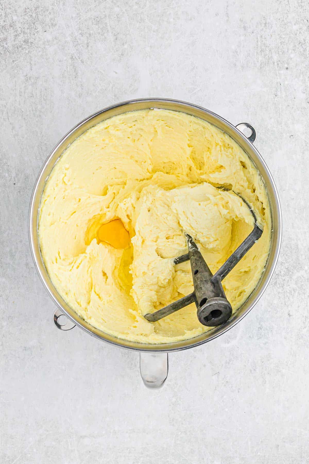 Egg added to the butter mixture in a mixing bowl.