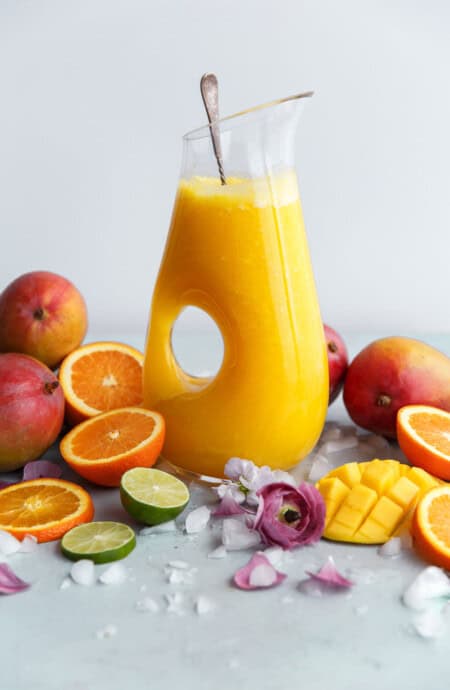 Mango fruit punch in a vessel surrounded by gorgeous fresh fruits