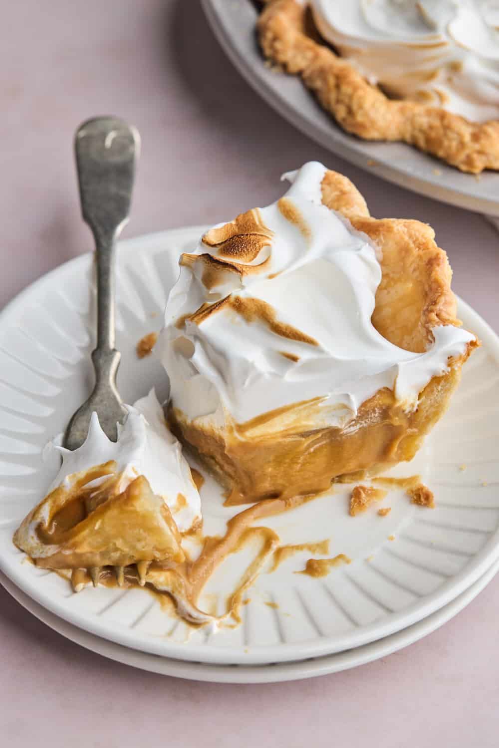 A slice of pie made with butterscotch being cut into with a fork