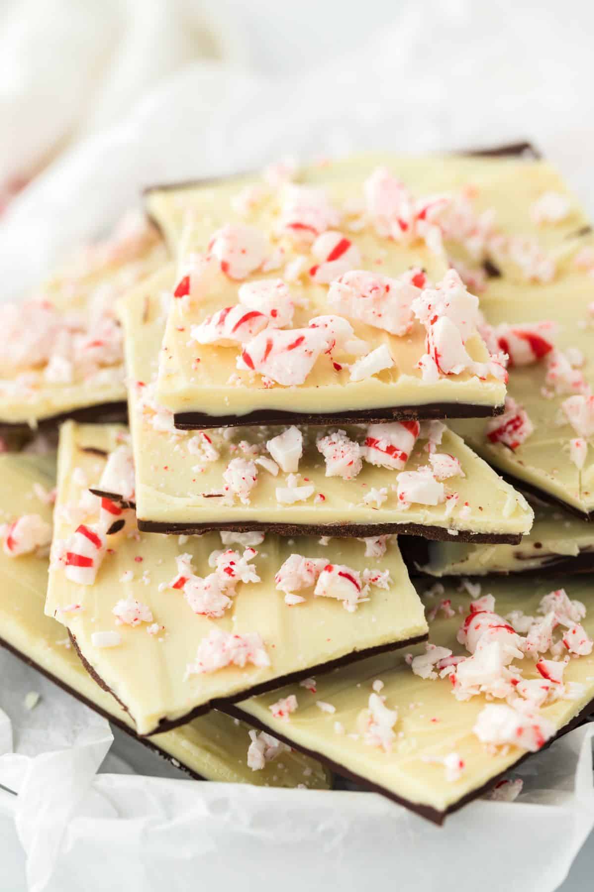 Chocolate bark pieces with white and dark chocolate layers stacked up on a plate.