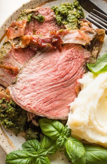 Beef roast and mashed potatoes on a stoneware plate.
