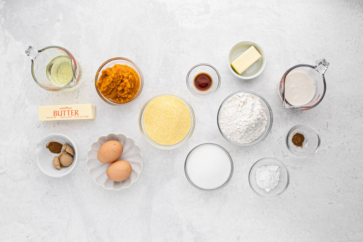 Ingredients for pumpkin cornbread in several bowls on the table before mixing up.
