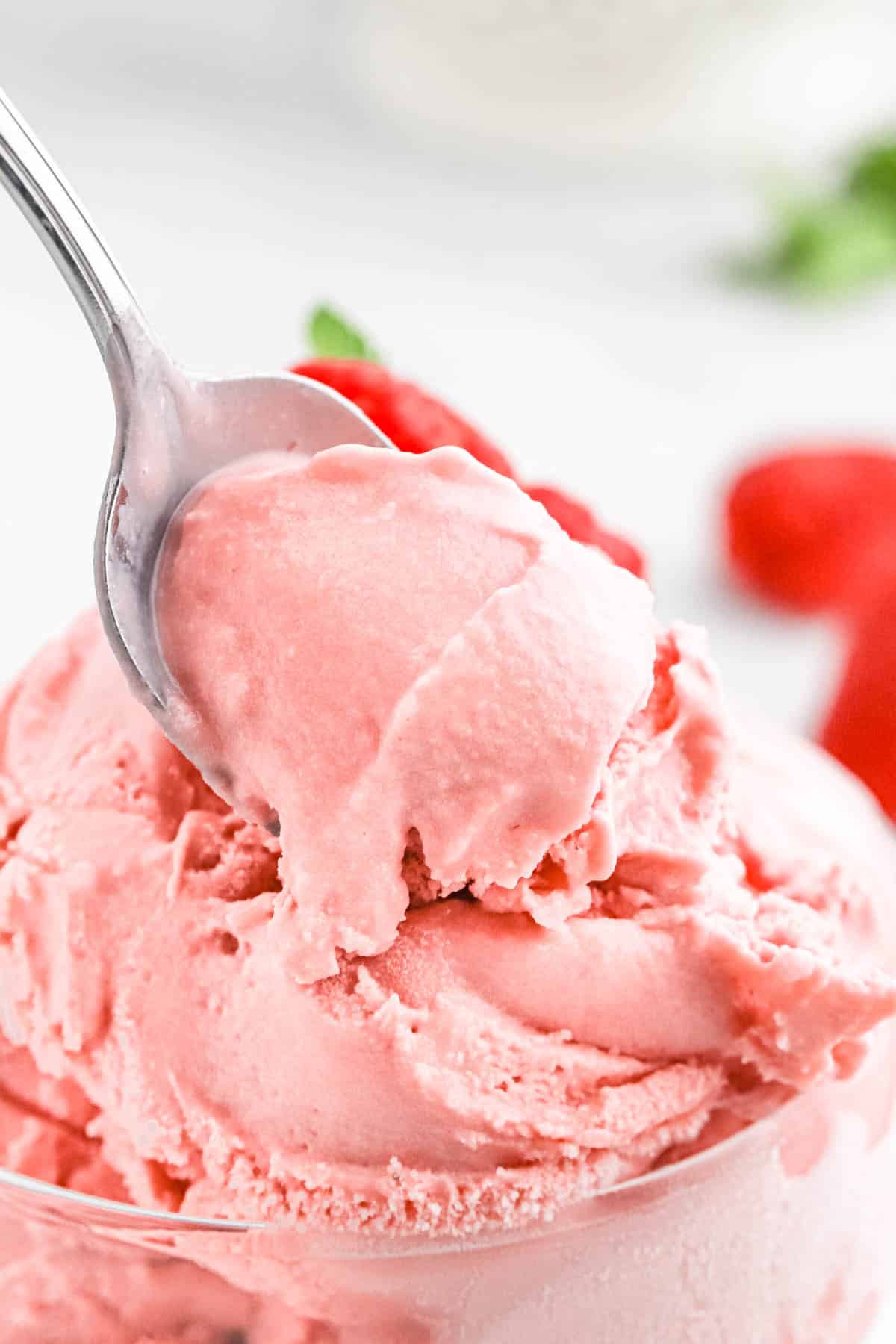 raspberry ice cream Close up of fresh raspberry ice cream on a spoon up over a bowl.
