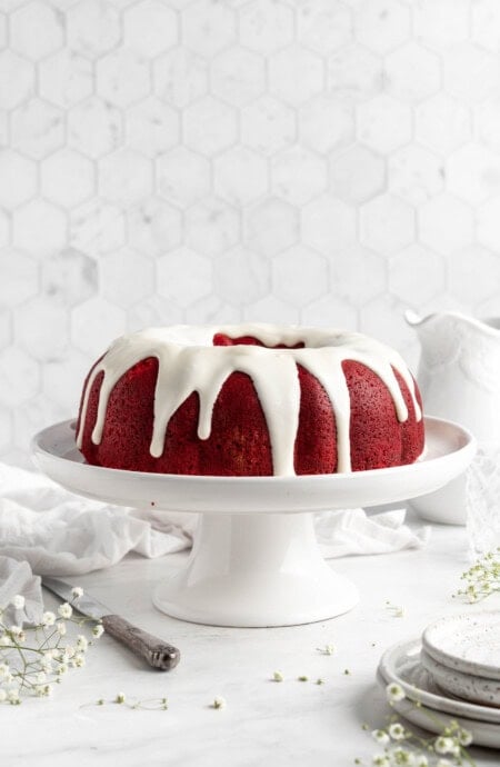 Iced red velvet bundt cake recipe on a cake pedestal