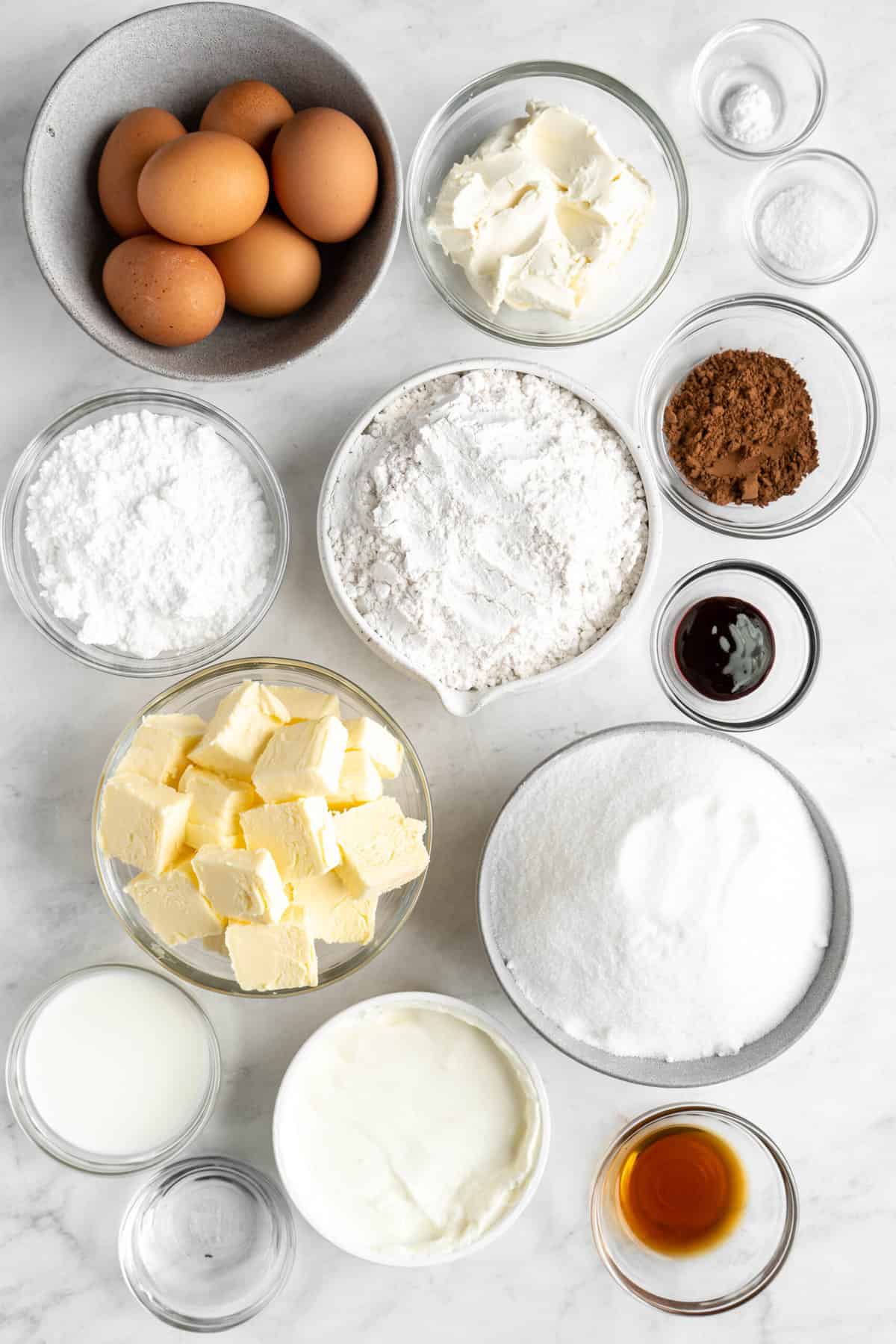 red velvet bundt cake ingredients in glass bowls on white countertop