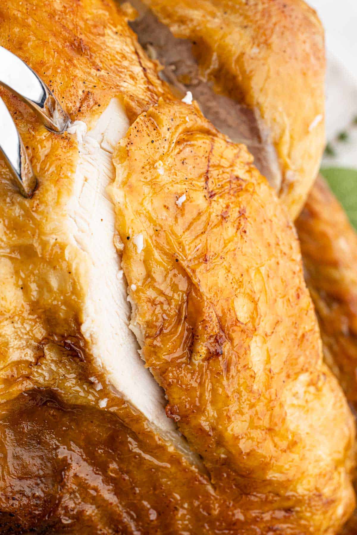Close-up of a golden-brown, crispy turkey breast being sliced