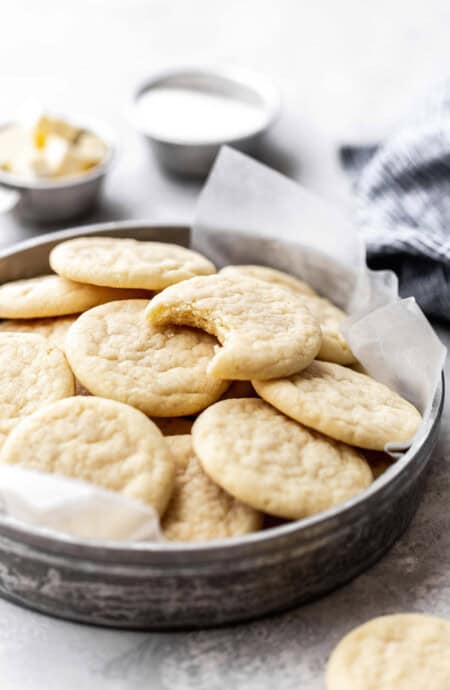 Close up of bitten into Southern Tea Cake on top of several cookies in tin