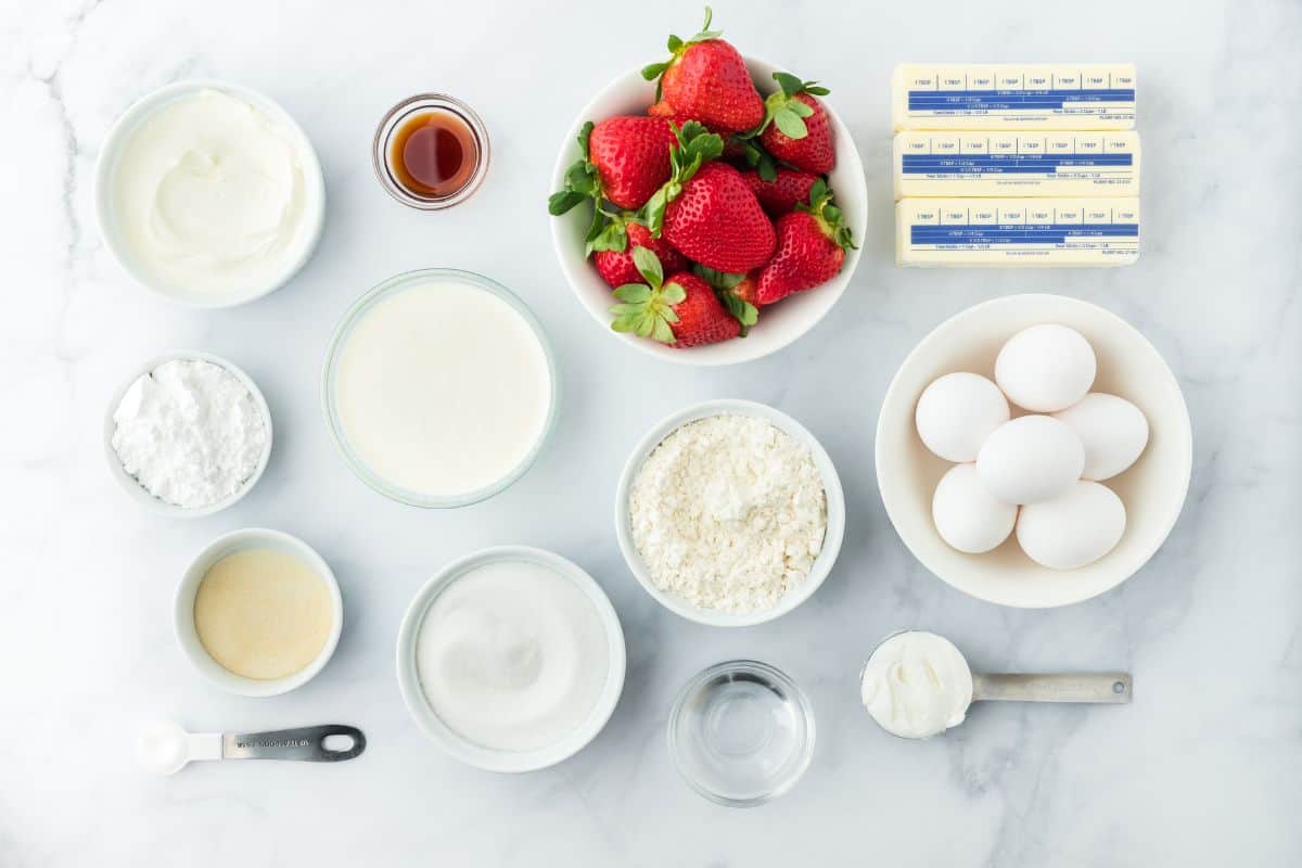 Overhead shot of ingredients to make strawberry shortcake pound cake on a white surface before mixing