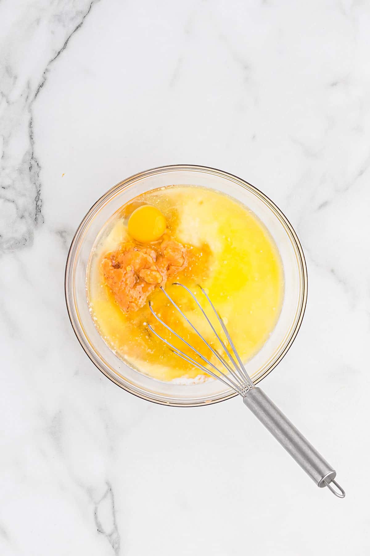 Wet ingredients in a bowl with a whisk.