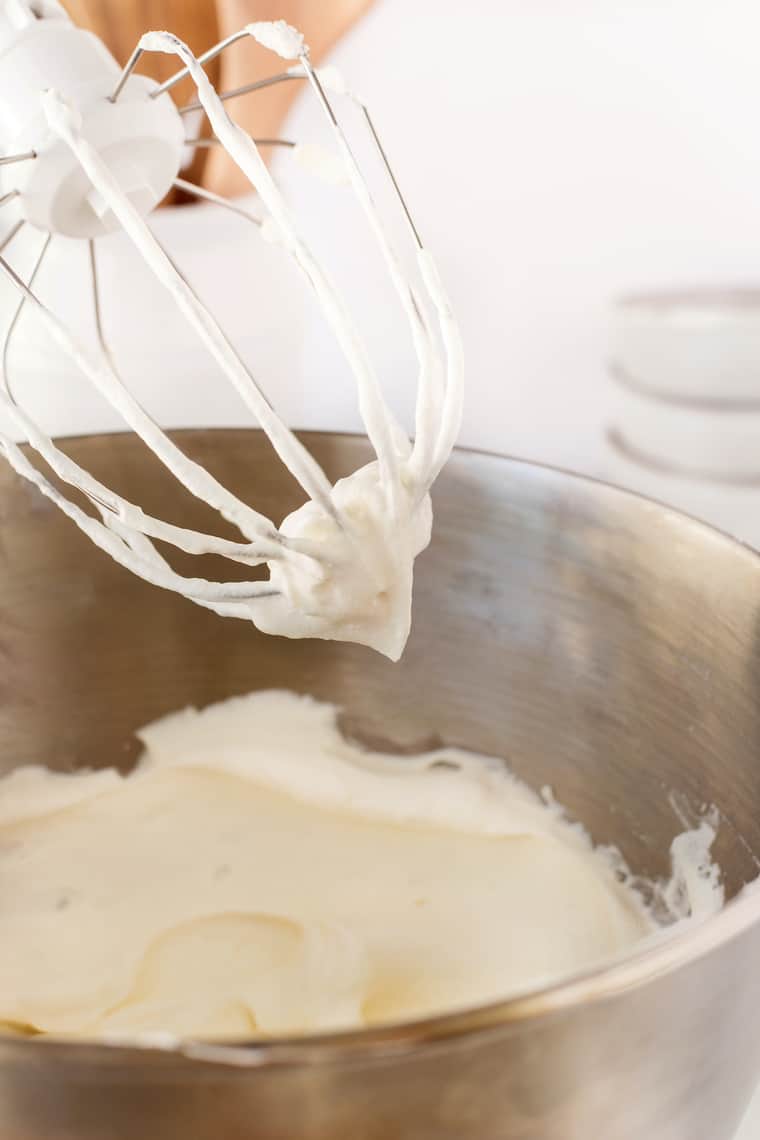 Heavy whipping cream whipped to stiff peaks on a stand mixer beater